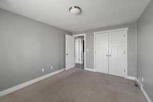Unfurnished bedroom with carpet flooring and a closet