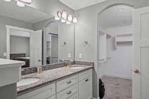 Full bathroom with double vanity and a spacious closet