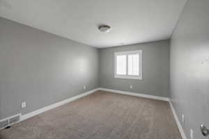 Carpeted spare room featuring baseboards and a textured ceiling