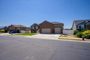 View of front of home featuring a gate, an attached garage, brick siding, driveway, and a residential view