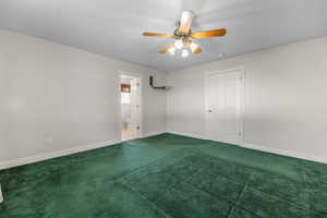 Unfurnished bedroom with a ceiling fan and carpet