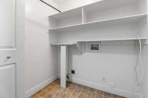 Laundry room with hookup for a washing machine, hookup for an electric dryer, and light tile patterned flooring