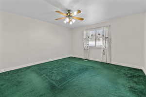 Spare room with ceiling fan and carpet flooring