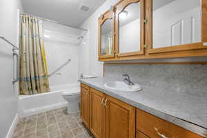 Bathroom featuring shower / bath combo, vanity, and light tile patterned floors