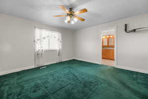 Unfurnished bedroom with a ceiling fan, carpet floors, and connected bathroom