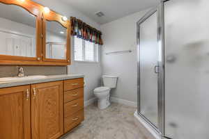 Full bath featuring vanity, a stall shower, and light tile patterned floors