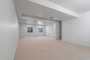 Unfurnished room featuring baseboards and light colored carpet