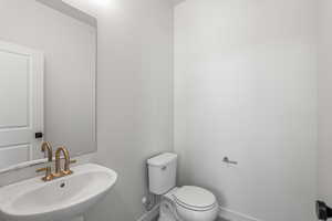 Half bathroom with a sink and baseboards