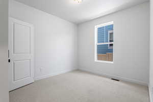 Carpeted spare room with baseboards
