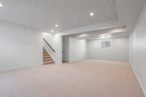 Finished below grade area featuring recessed lighting, stairs, and light colored carpet