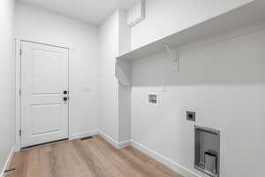 Laundry room featuring hookup for an electric dryer, washer hookup, and light wood-style floors
