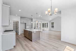 Kitchen featuring stainless steel appliances, recessed lighting, light wood finished floors, a chandelier, and light countertops