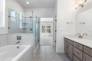Bathroom with vanity, a bath, a marble finish shower, marble finish flooring, and recessed lighting