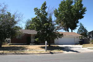 View of front of home featuring driveway, an attached garage, and brick siding