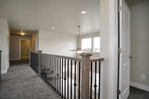 Hall with carpet flooring, recessed lighting, and an upstairs landing