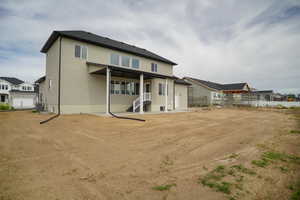 Rear view of house with stucco siding and a patio area