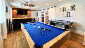 Game room featuring a ceiling pool table, air hockey table and bar seating