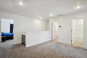 Spare room featuring light carpet, a textured ceiling, and recessed lighting