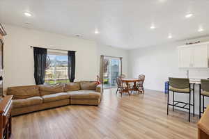 Living area featuring light wood finished floors and recessed lighting