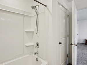 Primary Bathroom featuring bathtub / shower combination and baseboards