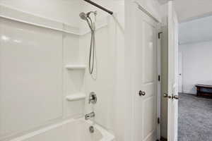 Full bath featuring shower / bathtub combination and carpet floors