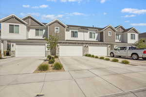 View of front facade with stone siding, driveway, a garage, and board and batten siding