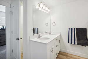 Bathroom featuring double vanity and light wood-style flooring