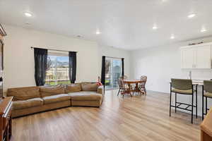 Living area featuring recessed lighting, light wood finished floors, and a textured ceiling