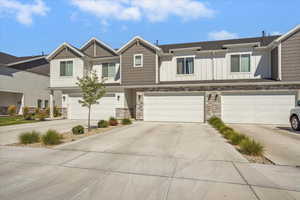 Craftsman-style house featuring stone siding, driveway, board and batten siding, and an attached garage