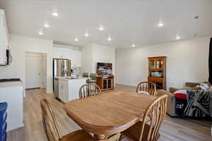 Dining room with light wood-style floors and recessed lighting
