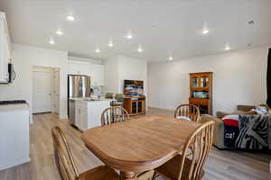 Dining space with light wood-type flooring and recessed lighting
