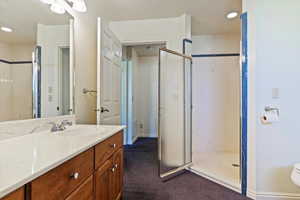 Full bathroom with a marble finish shower, vanity, and recessed lighting