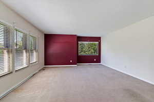 Carpeted empty room featuring healthy amount of natural light