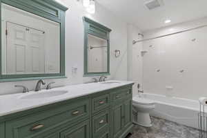 Full bathroom with double vanity and tub / shower combination