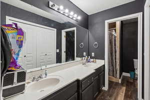Bathroom featuring double vanity and wood finished floors
