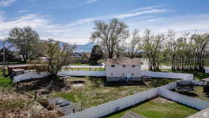View of property exterior featuring a trampoline, a fenced backyard, and a mountain view