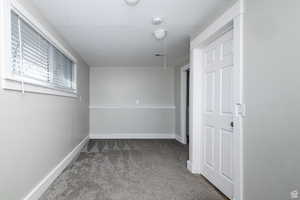 Spare room featuring carpet floors, a textured ceiling, and a smoke detector