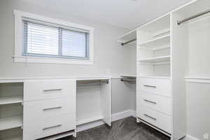 Walk in closet featuring dark colored carpet