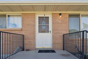 View of exterior entry with brick siding