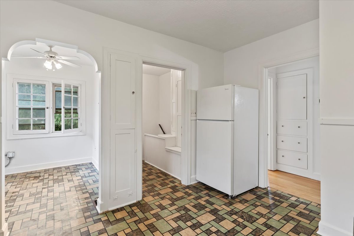 Kitchen with freestanding refrigerator, ceiling fan, and brick patterned flooring