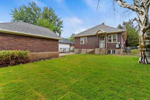 Rear view of property with brick siding and a chimney