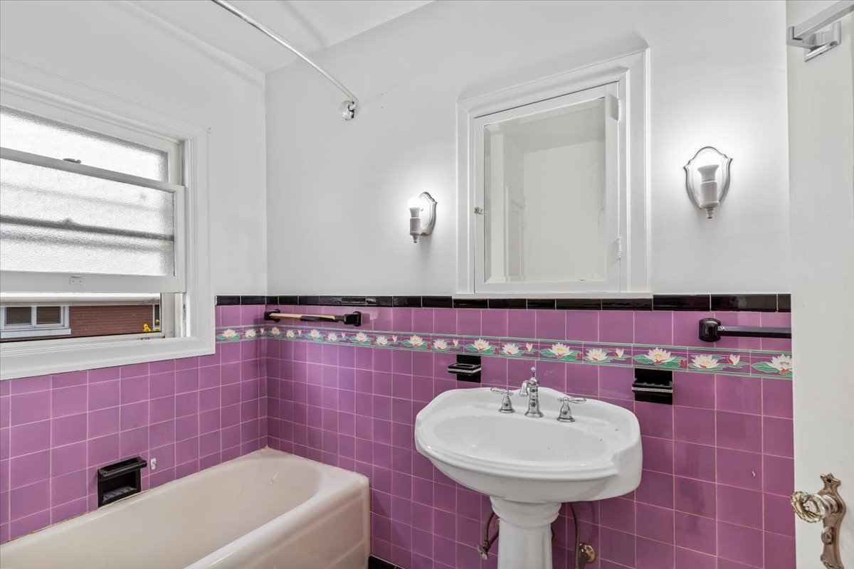 Full bath featuring tile walls, a bath, and a wainscoted wall