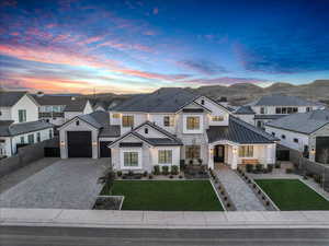 View of front of home with stone siding, a standing seam roof, decorative driveway, a residential view, and a metal roof