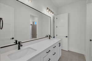 Bathroom with double vanity and tile patterned flooring
