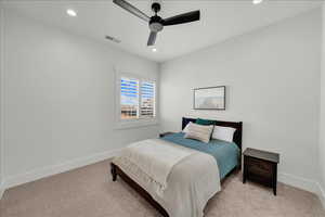 Carpeted bedroom featuring recessed lighting and a ceiling fan