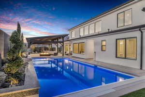 Swimming pool with outdoor lounge area, a patio, and a fenced backyard