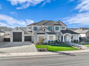 Modern farmhouse style home featuring decorative driveway, a standing seam roof, a garage, a metal roof, and stone siding