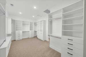 Walk in closet featuring light colored carpet