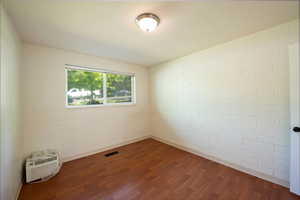 Spare room with dark wood finished floors and a wall mounted air conditioner