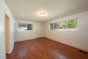 Foyer entrance with dark wood finished floors, healthy amount of natural light, and concrete block wall